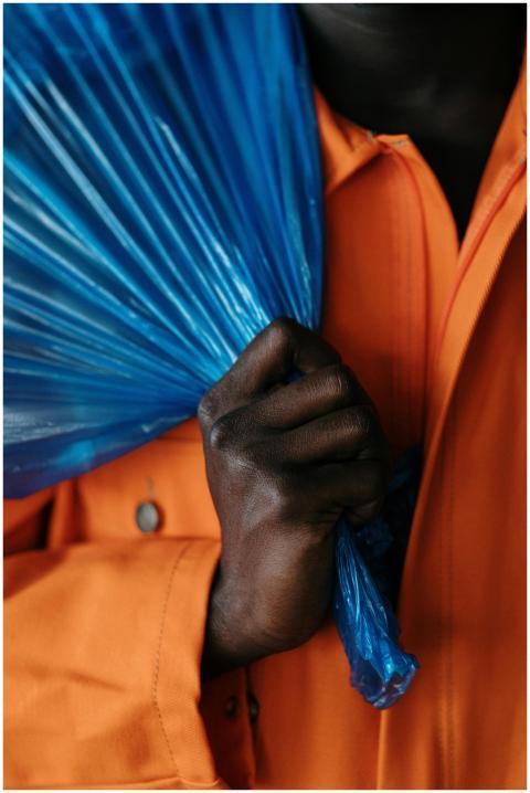 Detailed shot of a hand gripping a blue plastic ba