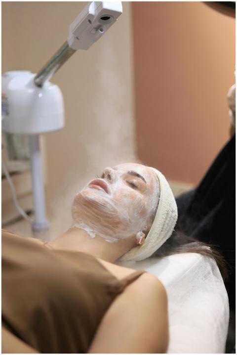 Woman enjoying a facial steam treatment in a seren