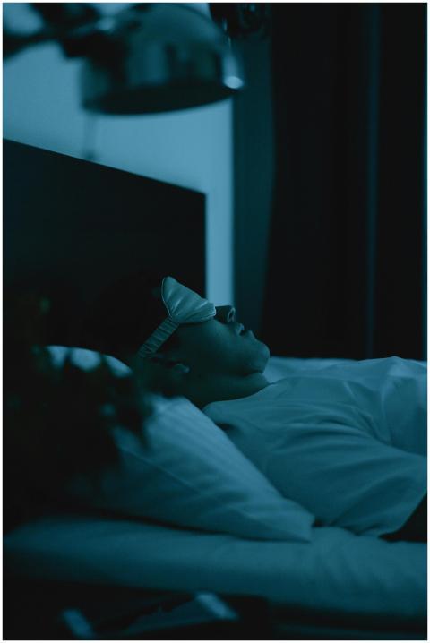 Adult resting peacefully in bed wearing a sleep ma