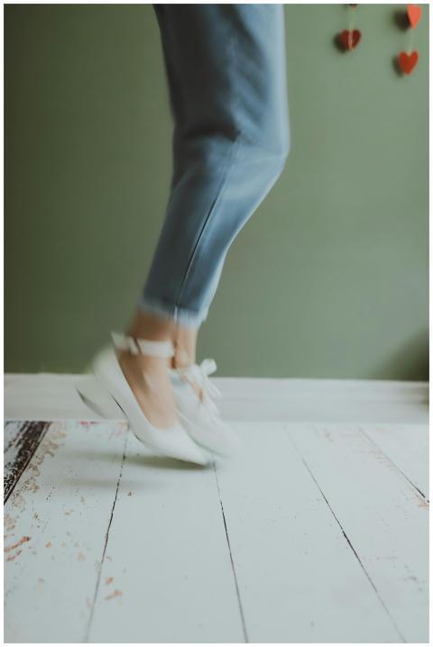 A blurred motion shot of a woman in white shoes ju