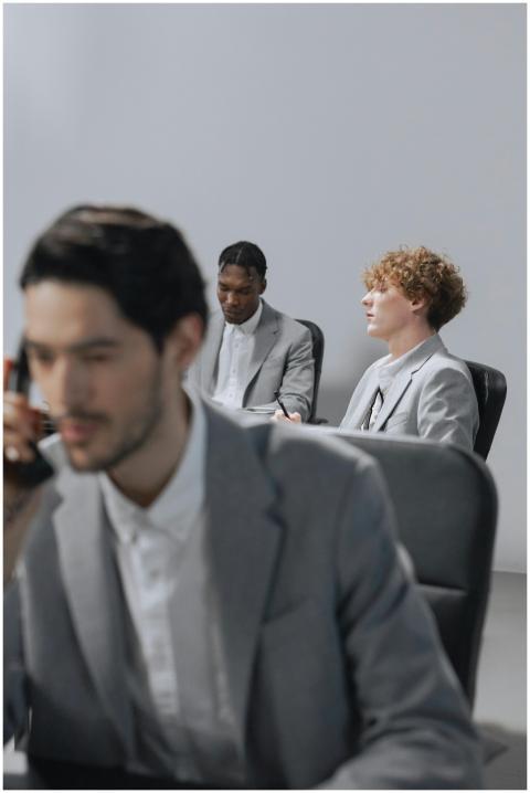 Three men in suits engaged in a focused business m