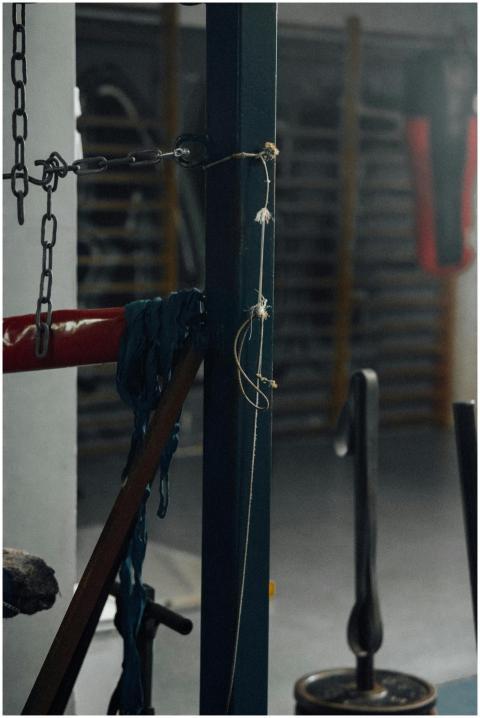 Close-up of boxing gym equipment with ropes and ch