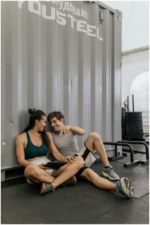 A couple in activewear relaxing and smiling indoor