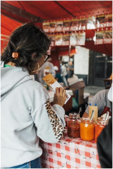 Woman holding food at a lively street food market