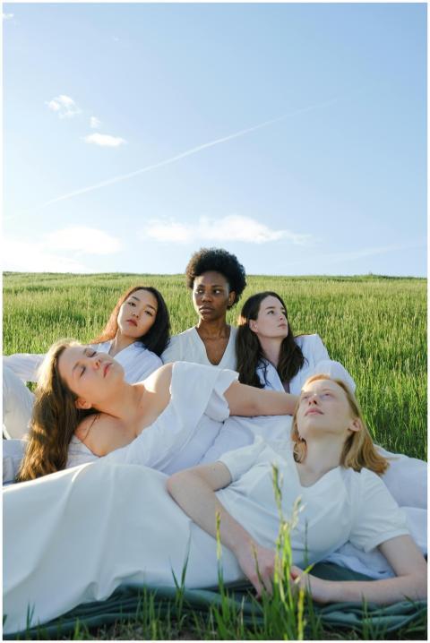 Group of diverse women relaxing in a green field u