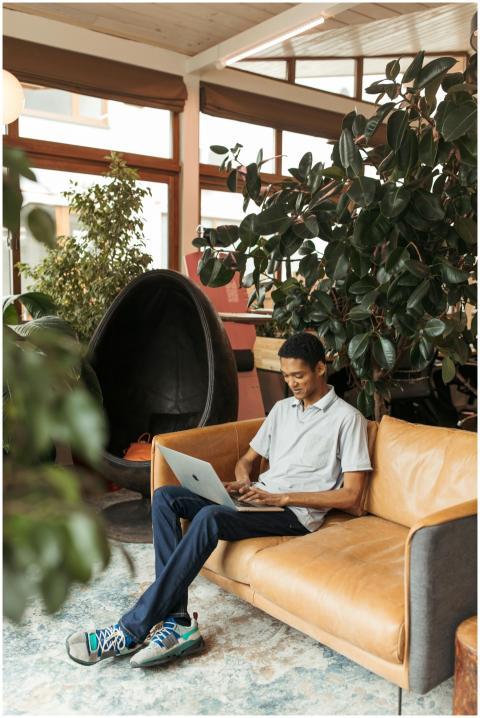 Man using laptop in a modern creative workspace su