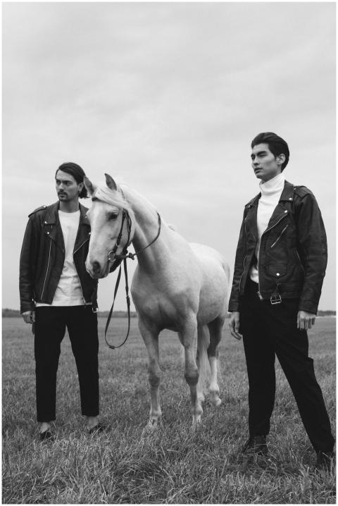 Two stylish men in leather jackets posing with a h