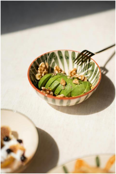 Fresh sliced avocado and walnuts in a patterned bo