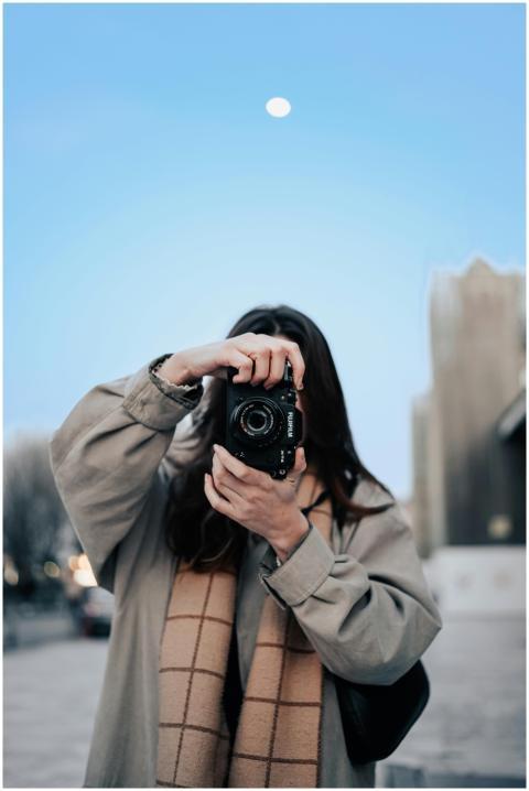 Stylish woman taking a photo with professional cam