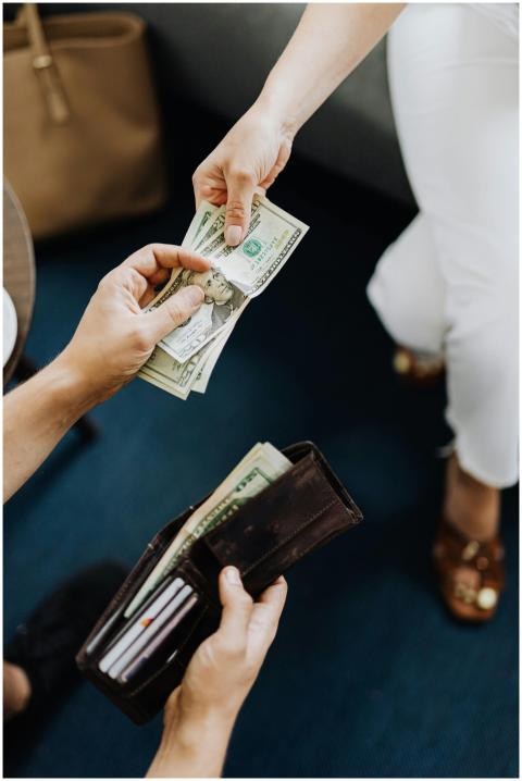 Close-up of hands exchanging cash, representing a
