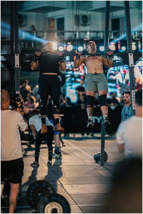 Athletes performing pull-ups at a vibrant fitness