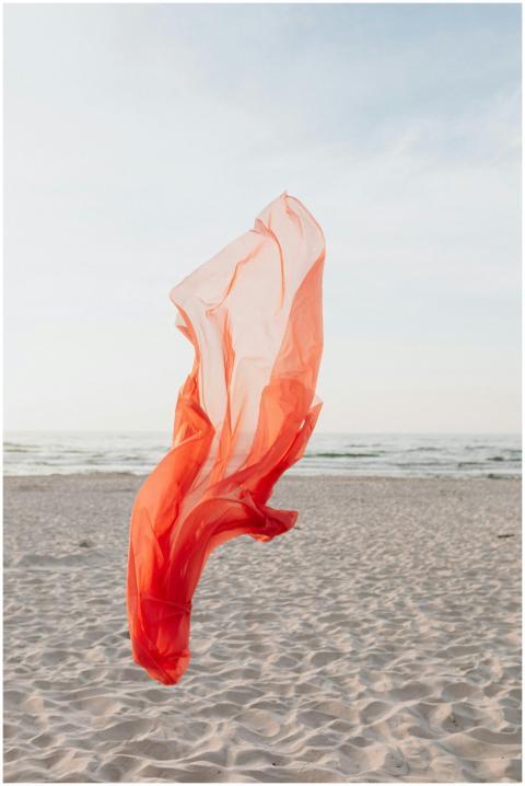 A vivid orange fabric floats gracefully over the s