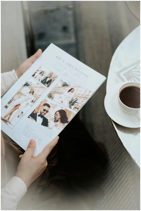 Person holding wedding magazine with coffee, focus