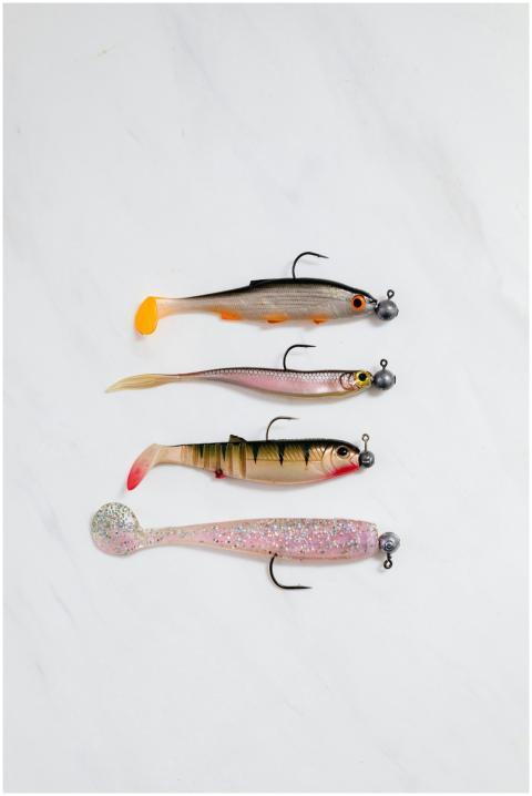 Top view of assorted fishing lures on a white surf