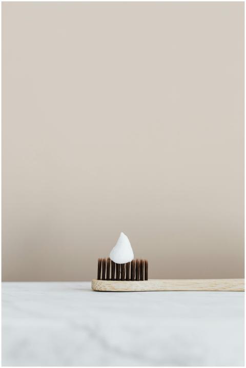 Elegant minimalist photo of a bamboo toothbrush wi