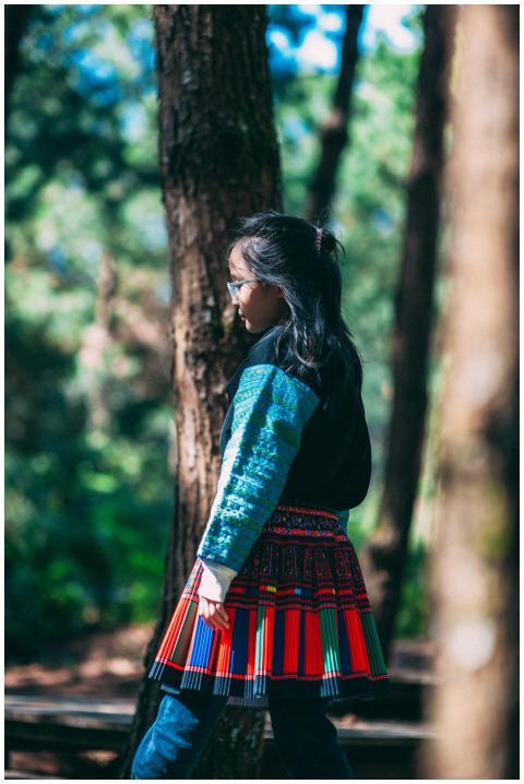 A young woman in traditional attire strolls throug