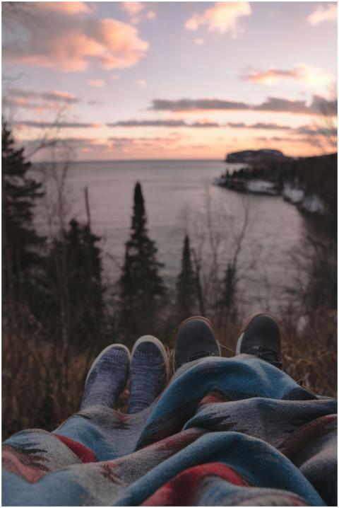 Couple relaxes under a blanket, watching the sunse