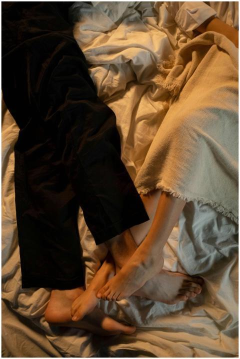 Intimate cozy moment with couple's feet intertwine