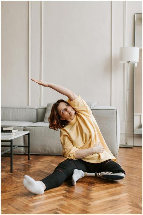 A woman with a prosthetic leg performs stretching