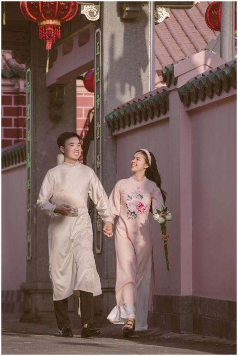 Happy couple walking in Vietnamese ao dai along a