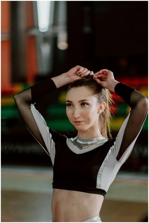 A young woman cheerleader in sportswear preparing