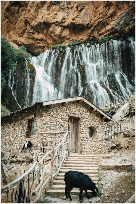 Scenic view of a stone house and waterfall in Kapu
