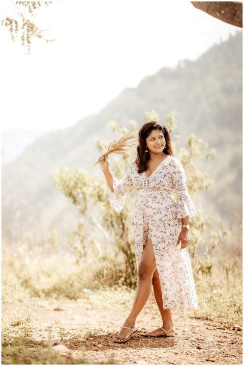 Elegant woman in floral dress posing outdoors with