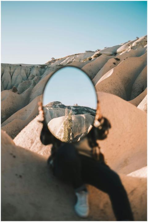 A person holds a mirror reflecting a Cappadocia la