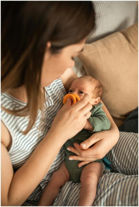 A mother tenderly feeds her newborn baby with a br