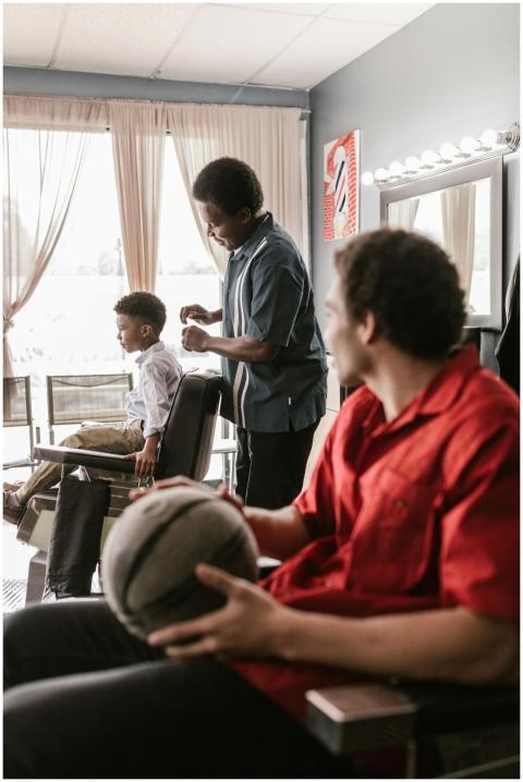 African American men and boy in a barbershop setti