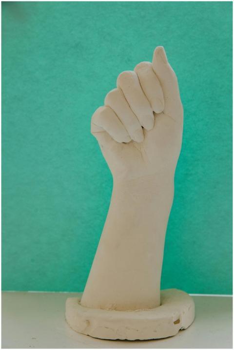 Plaster hand sculpture displayed in a studio setti