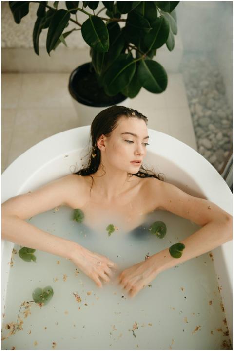 Woman enjoying a relaxing bath with natural leaves