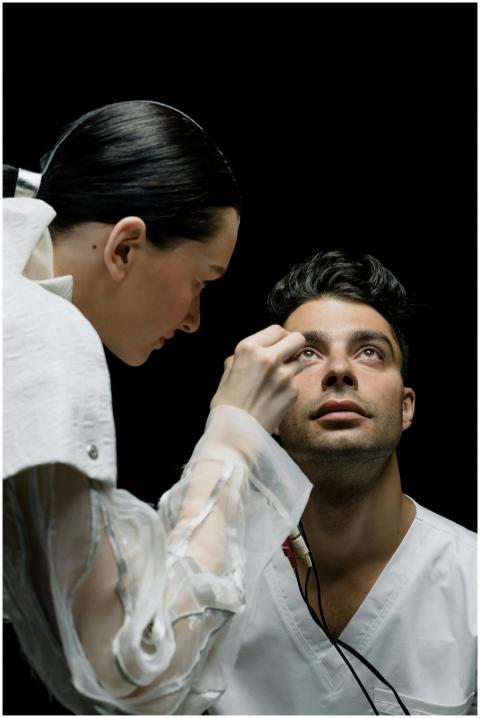 A female doctor conducts an eye examination on a m