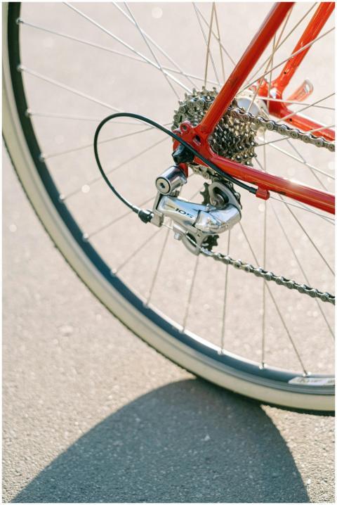 Detailed view of a bicycle wheel, gears, and red f