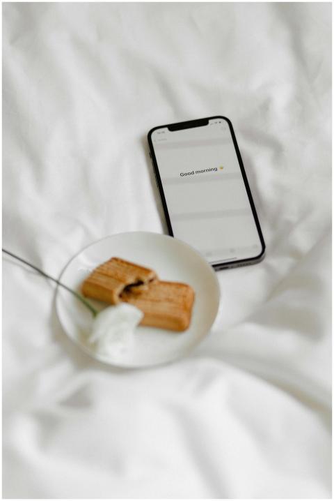 A cozy morning setup with a smartphone, biscuits,