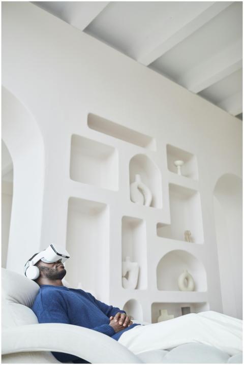 Man sitting on a sofa using a virtual reality head