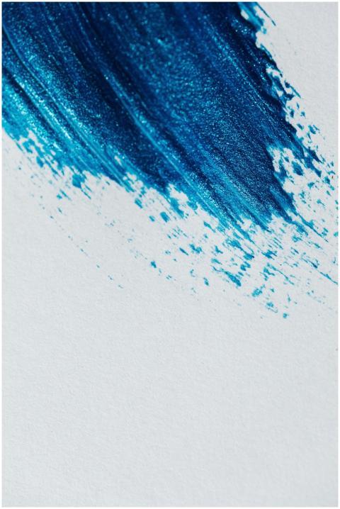 A close-up of an abstract blue brush stroke on a w