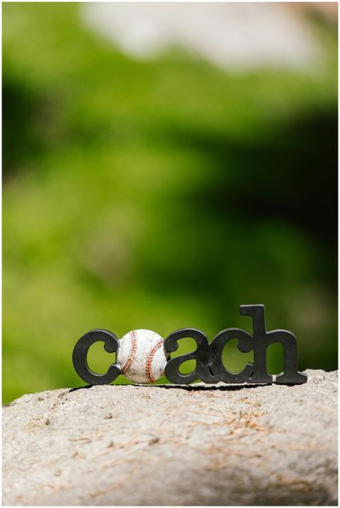 Close-up of a baseball and coach sign on a rock wi
