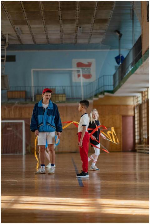 Gymnastics class with coach instructing children i