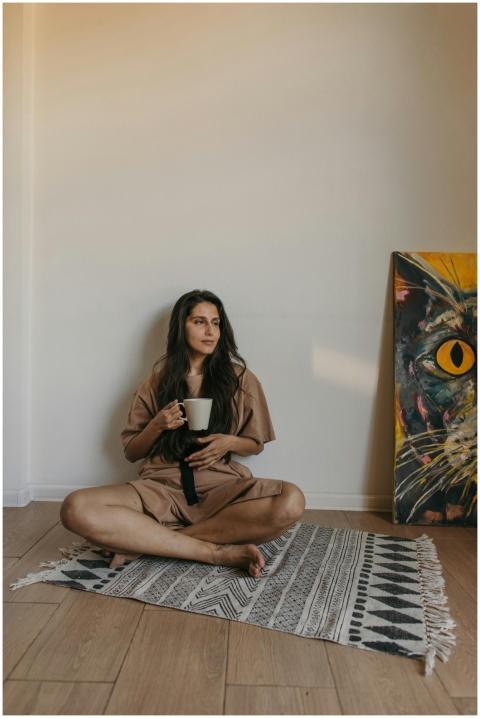 A young woman relaxes with coffee, sitting indoors