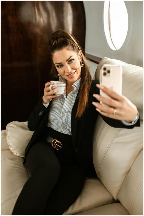 Stylish businesswoman relaxes with coffee, capturi