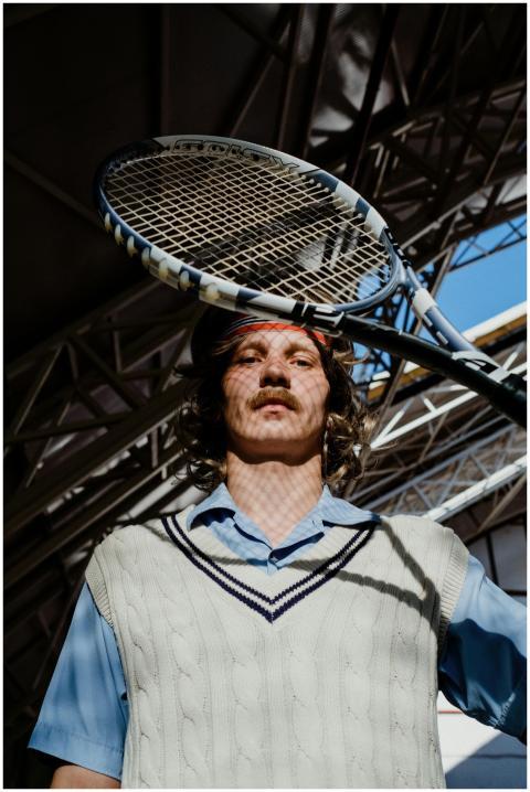 Stylish tennis player in a vintage outfit with a r