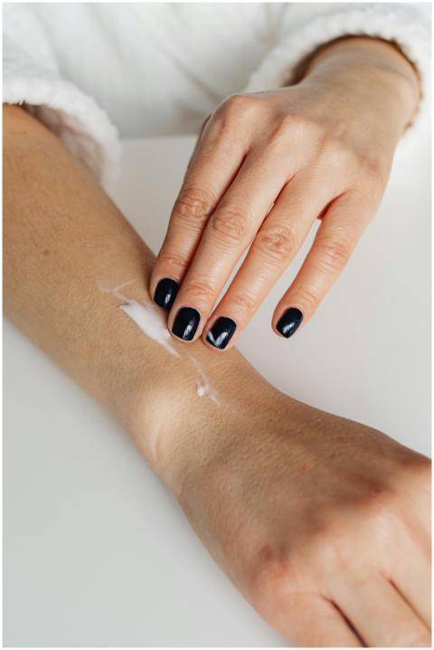 Close-up of a woman applying moisturizing cream on