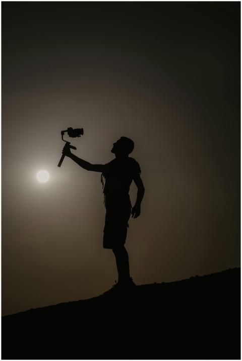 Silhouette of a man with camera, capturing a sceni