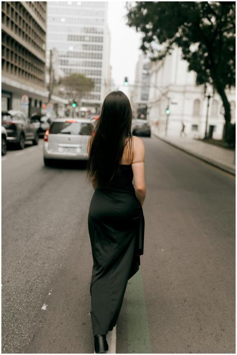 A woman walks down a city street, surrounded by ur