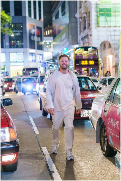 A man walks confidently down a bustling street in