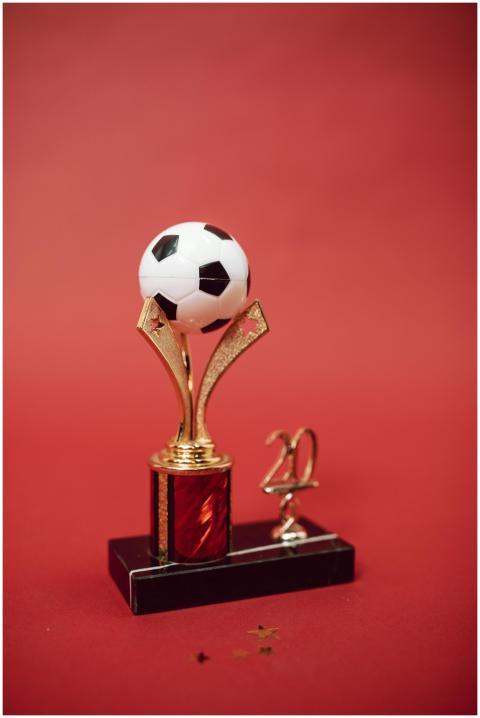 Elegant golden soccer trophy with red accents and