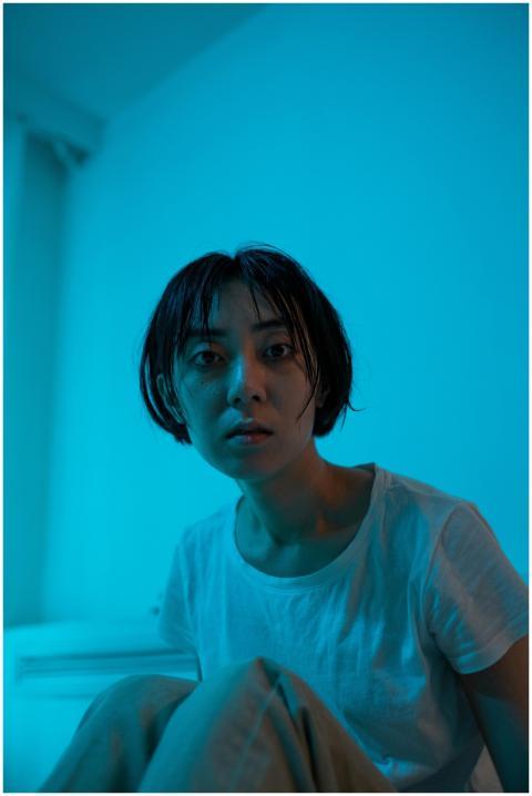 A thoughtful woman in blue light, conveying intros