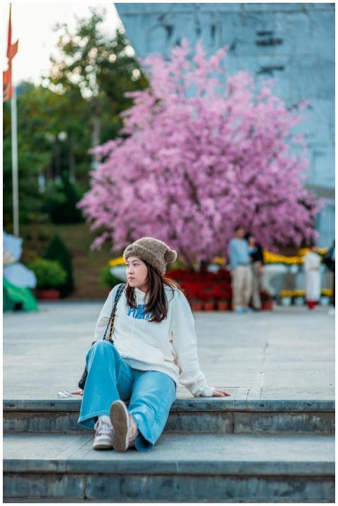 Young woman in street style fashion sitting on ste