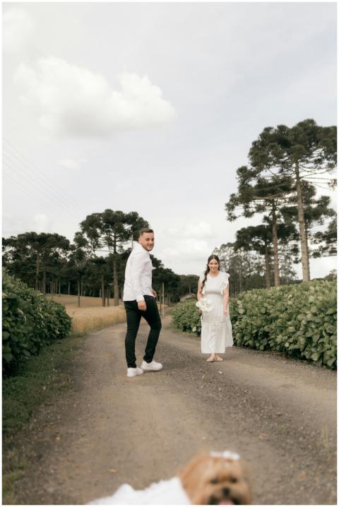 Smiling couple walks on a rustic path surrounded b